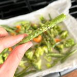 close-up-of-hand-holding-a-seasoned-greenbean