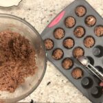 using-a-cookie-scoop-to-put-mini-muffin-batter-into-muffin-pan